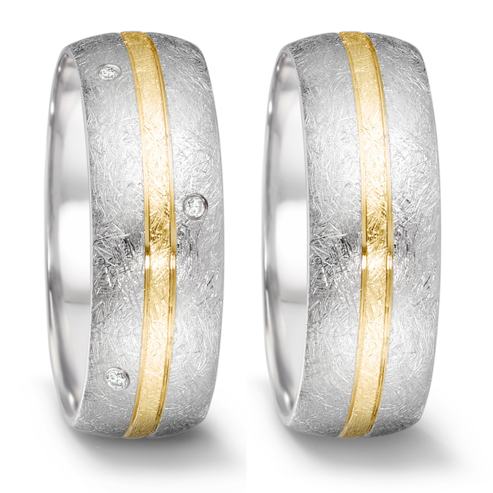 Partnerring Der handgefertigte Tamor Ring von TeNo vereint hohen Tragekomfort durch seinen weichen, halbrunden Querschnitt und polierte Innenwölbung mit zeitloser Eleganz und minimalistischem Design. Der schmale Gelbgoldstreifen, der endlos um den eismatten Edelstahlring verläuft, betont stilvoll die funkelnden Diamanten, die rundum versetzt gefasst sind. TeNo Partnerringe sind langlebige Begleiter für Freundschaft, Beziehung oder den Bund fürs Leben.  068.26S01.D56.XX Gelbgold