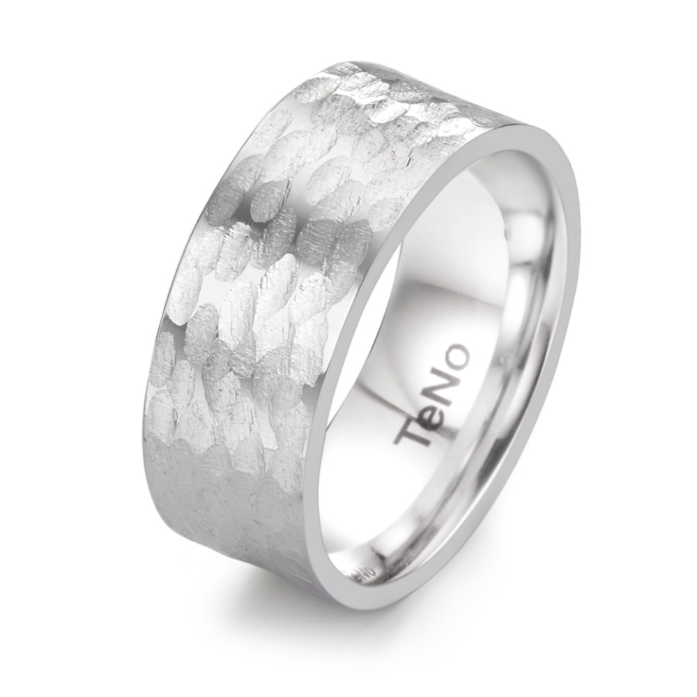 Fingerring Der Fingerring Drakon von TeNo Design verkörpert Kraft und Faszination. Mit seiner handgearbeiteten Struktur, die an die Schuppenhaut mächtiger Fabelwesen erinnert, ist dieser breite Edelstahlring ein beeindruckendes Schmuckstück. Robust und langlebig, betont dieser Ring Individualität und Persönlichkeit. Handmade in Deutschland aus recyceltem Edelstahl - ein zeitloses Accessoire mit Charakter. 069.1000.D86.XX