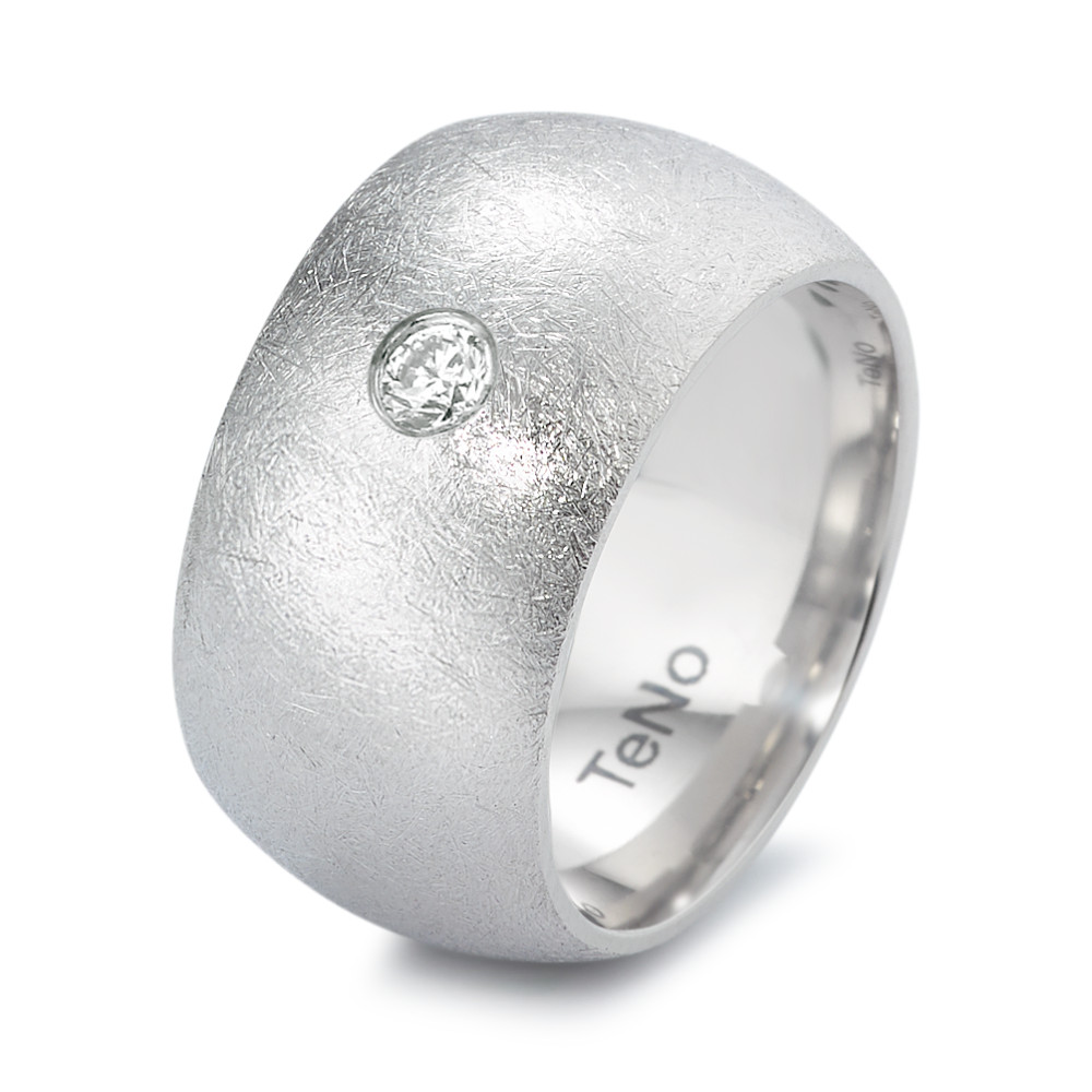 Fingerring Dieser markante Ring von TeNo vereint modernes Design mit einzigartiger Haptik. Gefertigt aus hochwertigem Edelstahl, besticht er durch seine eismatte Oberfläche, die dem Schmuckstück eine aussergewöhnliche, fast frostige Struktur verleiht. Ein funkelnder Diamant setzt einen edlen Akzent und unterstreicht das minimalistische Design. Der breite Ring liegt angenehm am Finger und bietet eine kraftvolle, aber zugleich elegante Ausstrahlung. Hergestellt in Deutschland steht er für höchste Verarbeitungsqualität und zeitlose Ästhetik - perfekt für alle, die klare Linien und besondere Oberflächen lieben. 369.3511.XX
