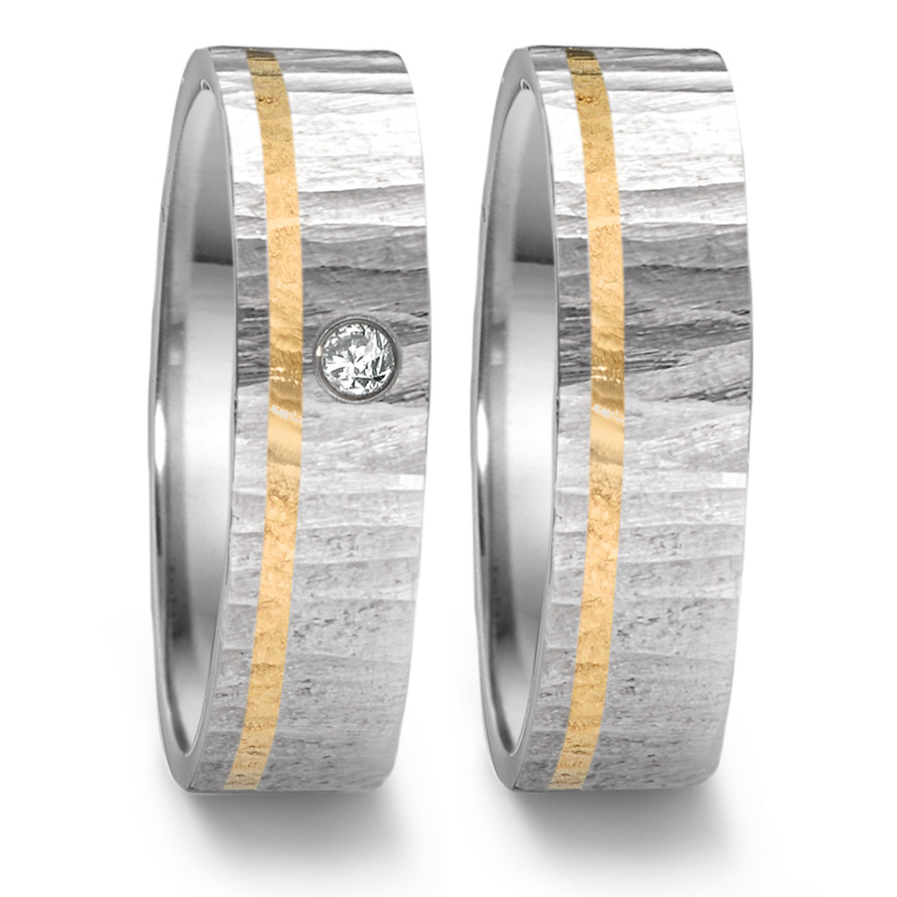 Partnerring Dieser markante Partnerring aus der Tamor Kollektion von TeNo mit "OAKTREE" Struktur besteht aus 18 Kt. Gelbgold mit Edelstahl und einem strahlenden Diamanten. Die Einkerbungen erinnern an die Rinde eines Baumes und entstehen in aufwendiger Handarbeit. Durch das besondere Design und die Verwendung hochwertiger Materialien vereint dieser Ring symbolische Bedeutung mit individuellem Stil. 468.1314.D30.XX