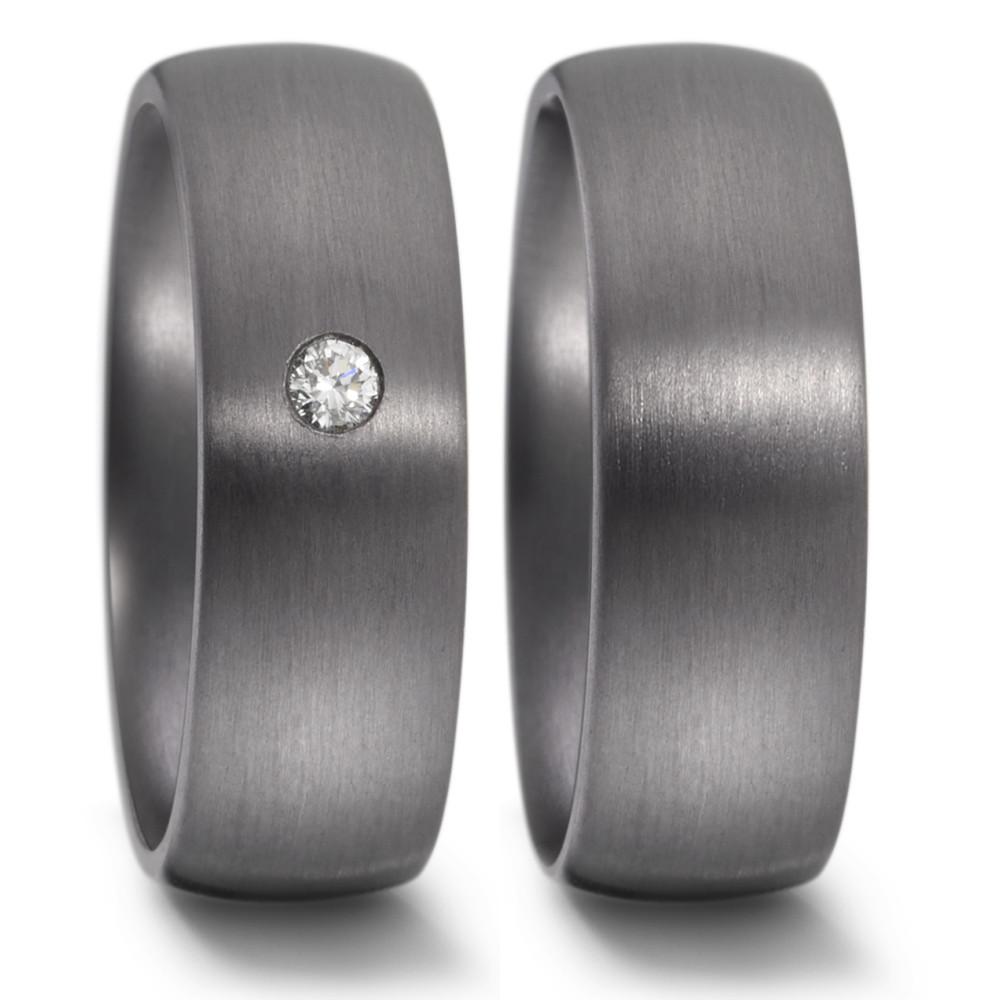 Fingerring Dieser exklusive Tantalring mit seiner glatten und dunkelgrauen Oberfläche sorgt für ein ansprechendes Gefühl beim Tragen und macht den Ring ästhetisch sehr ansprechend. Handgefertigt in Deutschland besticht der 7 mm breite und leicht gewölbte Ring mit einem funkelnden Diamanten von 0.05 Carat in der Mitte. Sein zeitloser Stil macht ihn zu einem eleganten Begleiter für Freundschaft, Partnerschaft oder Ehe. Stark, beständig und kostbar! 