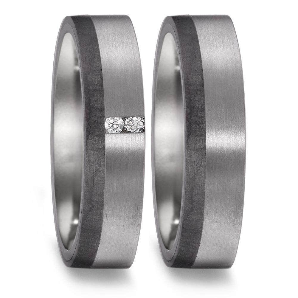 Partnerring Partnerringe symbolisieren die einzigartige Verbindung zweier Herzen. Dieser Partnerring ist aus 999 Tantal gefertigt und veredelt durch einen Streifen aus schwarzem Carbon. Zusammen lassen diese Materialien ein interessantes Farbspiel verschiedener Grautöne entstehen. Das matte Finish des Rings unterstreicht den avantgardistischen Charakter dieses Rings perfekt. Der Damenring wird durch das Einbetten von zwei funkelnden Diamanten zusätzlich veredelt. Ein Ring, der neben seinen optischen Eigenschaften aber auch durch seine aussergewöhnliche Widerstandsfähigkeit genau die richtige Wahl für Paare ist, die nach dem gewissen Etwas suchen.  52580/001/003/XN62