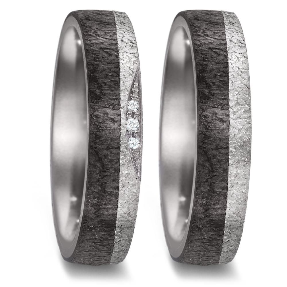 Partnerring Dieser einzigartige Partnerring kombiniert die aussergewöhnlichen Materialien Tantal und Carbon für ein modernes und robustes Design. Der Ring zeigt eine beeindruckende Struktur in seiner texturierten Oberfläche. Der Damenring wird zusätzlich von funkelnden Diamanten akzentuiert, die dem Ring einen Hauch von Eleganz und Glamour verleihen. Der Ring ist aussen und innen leicht bombiert, was für einen hohen Tragekomfort sorgt. Ein Ring, perfekt für Paare, die auf der Suche nach etwas Besonderem und Langlebigem sind. 52590/001/002/XN62