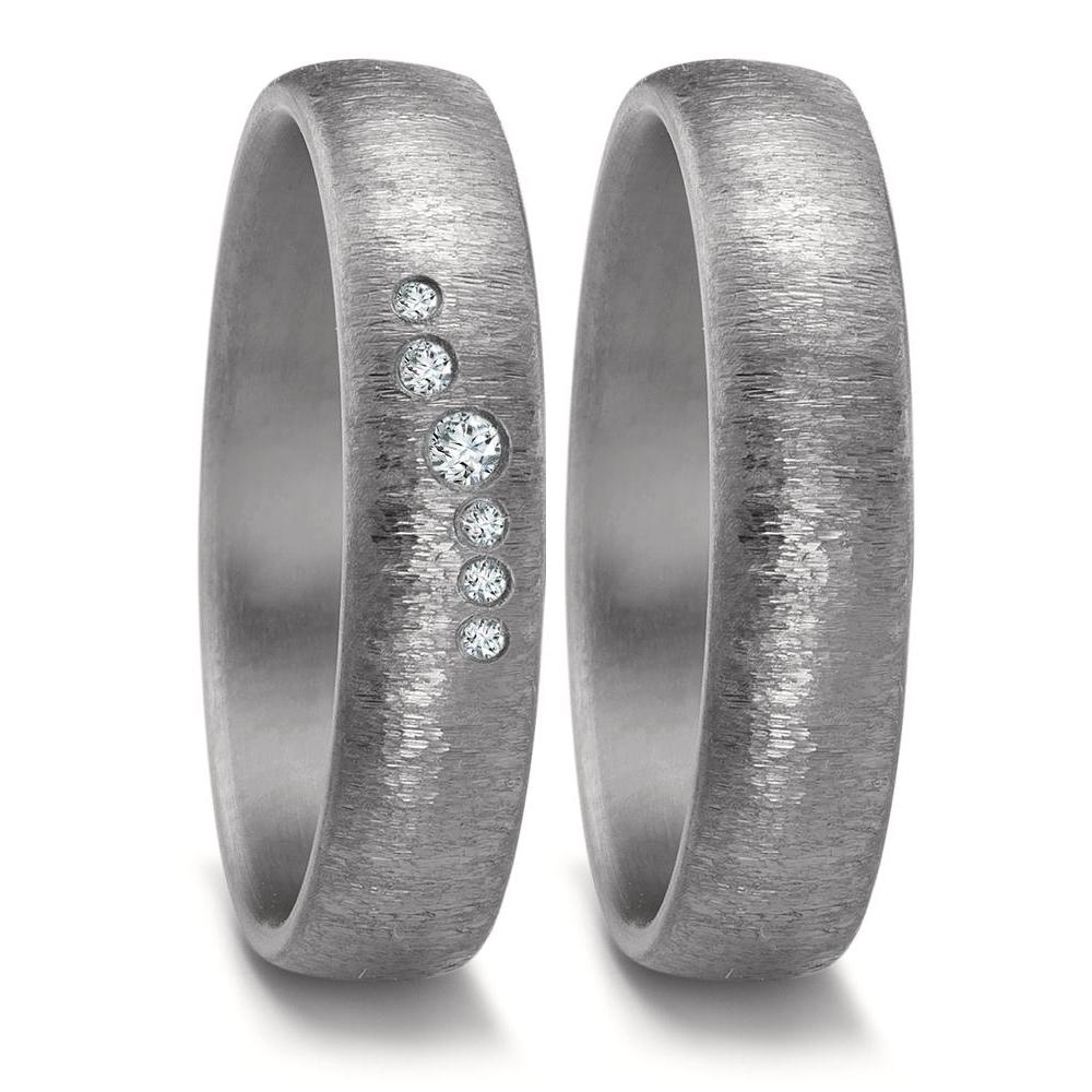 Partnerring Dieser exquisite Ring aus Tantal besticht durch seine einzigartige graphitgraue Farbe und das moderne, klare Design. Tantal, ein seltenes und äusserst robustes Metall, zeichnet sich durch seine aussergewöhnliche Härte und Beständigkeit aus. Es ist hypoallergen und daher ideal für empfindliche Haut geeignet. Die dunkle Eleganz des Tantals bildet einen faszinierenden Kontrast zu funkelnden Diamanten und verleiht dem Ring eine zeitlose Ästhetik. Ein Schmuckstück für Individualisten, die Wert auf Langlebigkeit und aussergewöhnliches Design legen. 