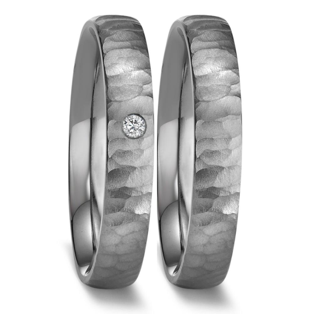 Partnerring Eleganter Damen-Partnerring aus 999 Tantal mit einer markanten, gehämmerten Oberfläche. In das edle Design ist ein funkelnder Diamant eingearbeitet, der für einen stilvollen Akzent sorgt. Perfekt für besondere Momente und symbolische Verbindungen. 52670/B03/DA3/X000